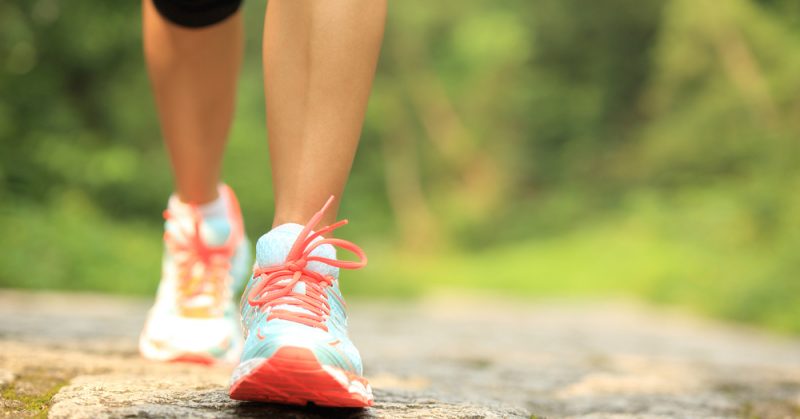 Person walking on pavement in laced up sneakers