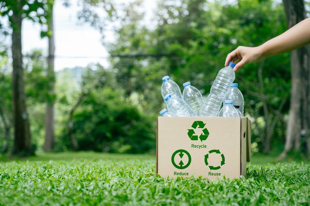 Recycle reduce reuse in zero waste concept. Hand holding plastic bottle put in a box recycling to assortment management for sustainable environment. garbage recycling to eco friendly.