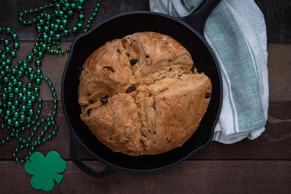 Photograph of Irish Soda Bread baked in a cast iron skillet for Saint Patrick's Day with Shamrock Beads
