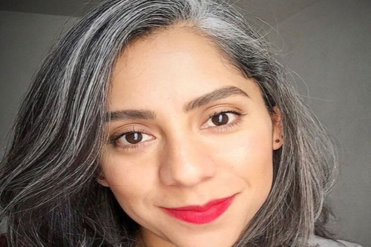 Woman smiling with black and grey hair