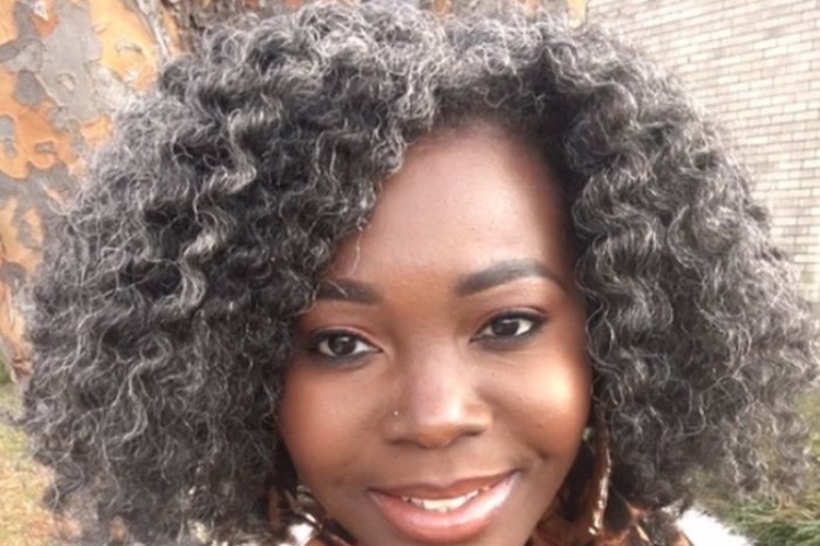 Black woman smiling with salt and pepper short wavy hair