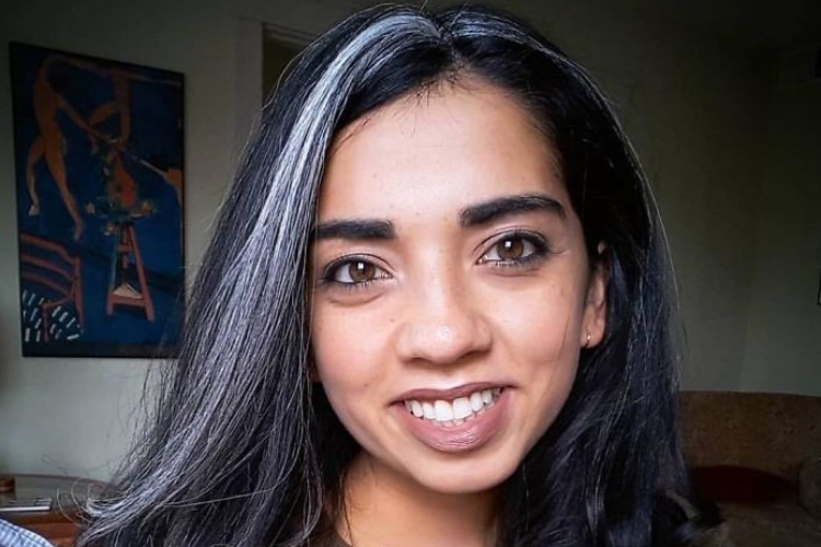 Woman smiling with nice teeth and long black hair with streaks of grey