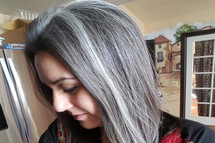 Side view of a light skinned woman with Black and White hair