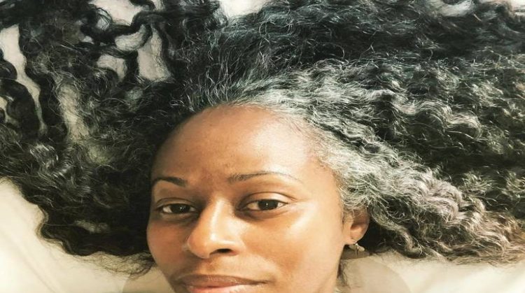 The gray plays beautifully with her curls, creating a stunning interplay of texture and color. 
