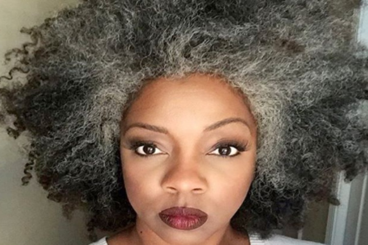Black woman with short and very curly black and white hair