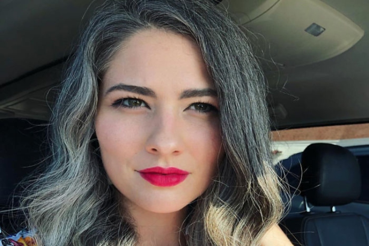 Woman with vibrant red lipstick and salt and pepper hair
