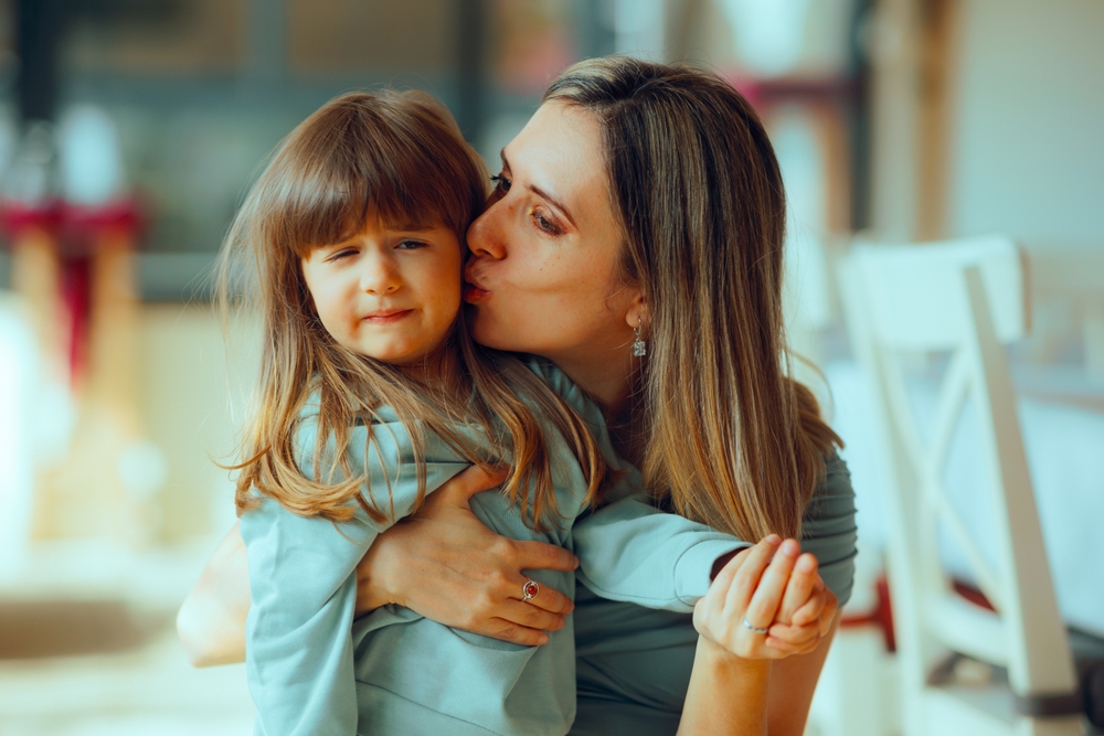 Funny Kid Rejecting Kisses from a Persistent Aunt. Little girl annoyed with all the attention and affections he gets