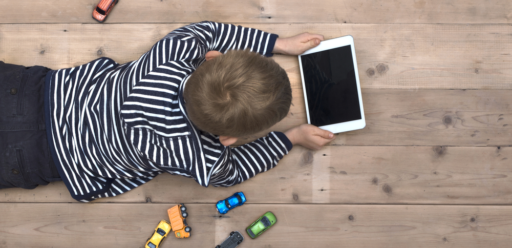 Modern generation. Kid playing on ipad