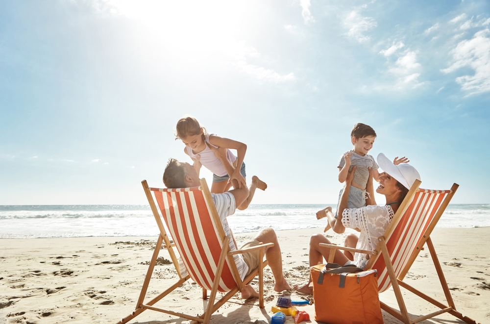 Family, beach and kids relax chair vacation adventure, bonding and play game together on tropical summer. Parents, children and excited of ocean island, energy and sunshine travel in Greece