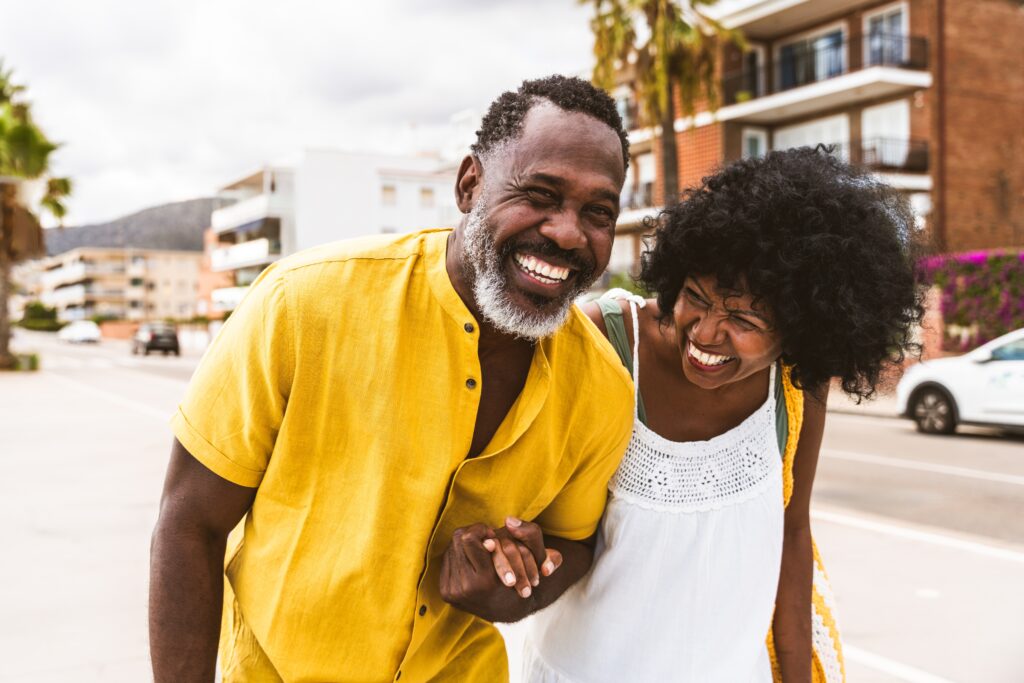 Beautiful mature black couple of lovers dating at the seaside - Married african middle-aged couple bonding and having fun outdoors, concepts about relationship, lifestyle and quality of life

