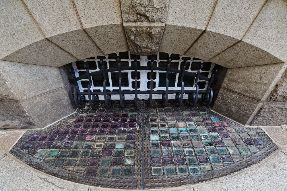 Arched basement window-decorative iron grillwork-colored glass pavement lights. Brisbane-Australia-048