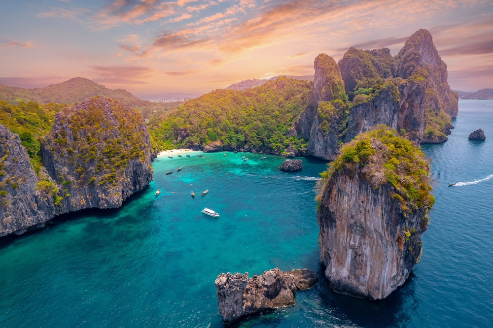 Aerial view paradise Nui beach, turquoise lagoon with white coral sand and palms on sunset time. Landscape koh Phi Phi Don island, Krabi, Thailand.