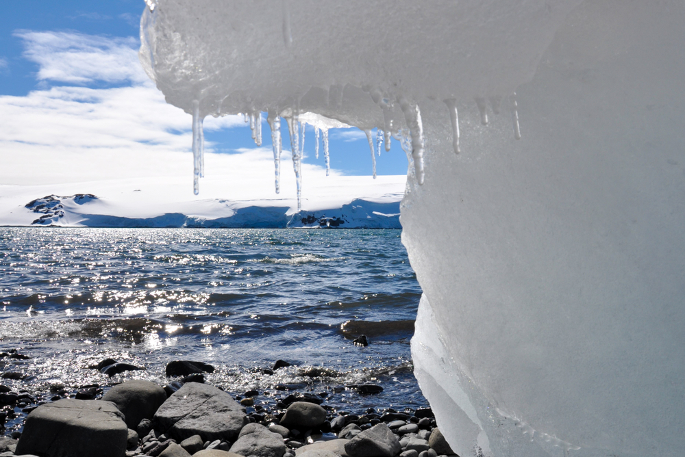 Cold landscape: snowy mountains, frozen water, ice stalactites in the seacoast. Antarctica
