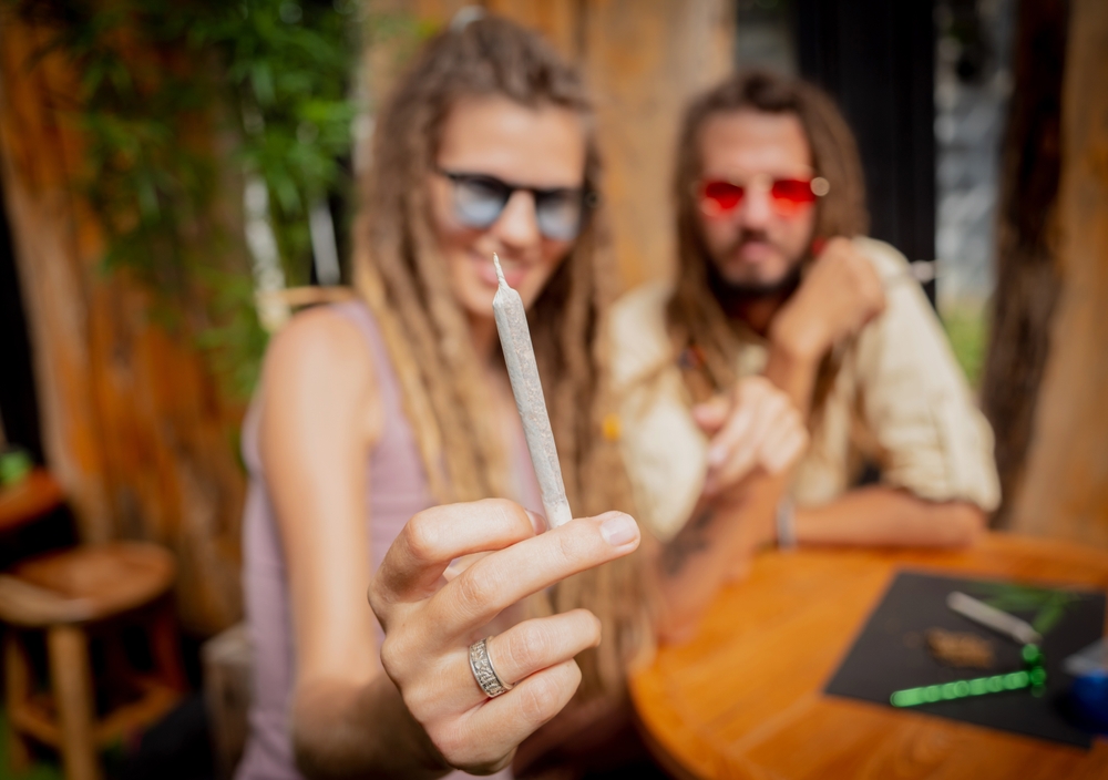 Hippie style couple smoking cigarettes with medical marijuana