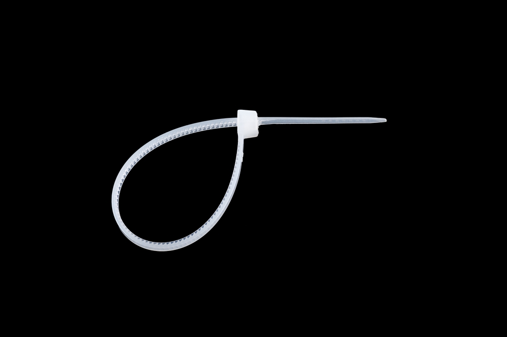 White plastic cable ties isolated on black background. plastic wire ties close-up.
