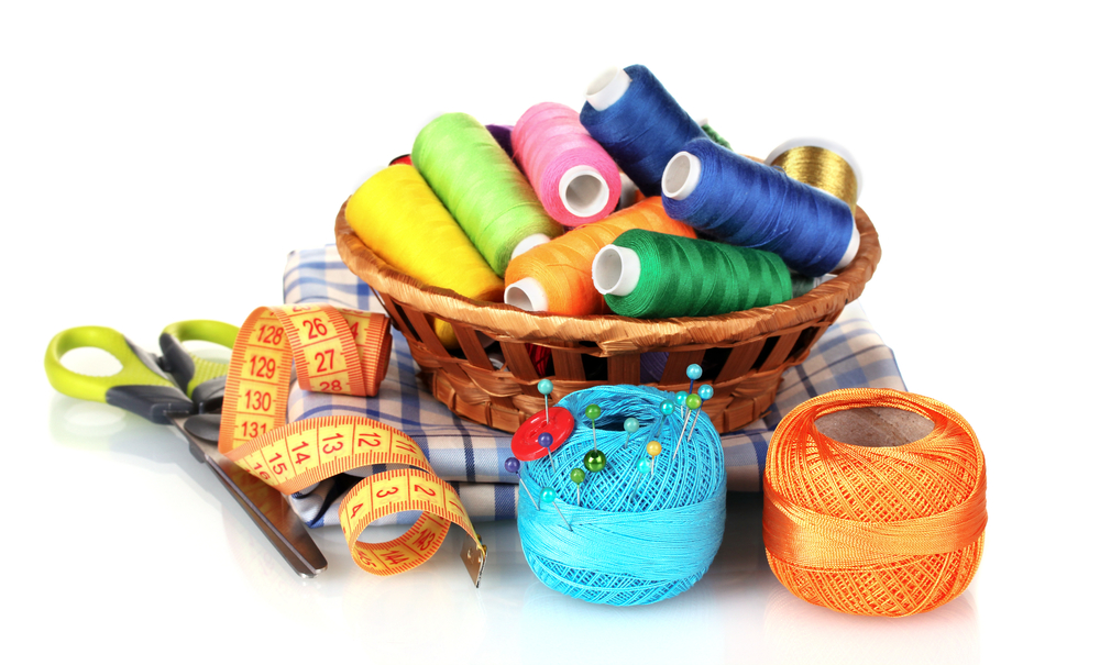 bright threads in basket, scissors and measuring tape isolated on white
