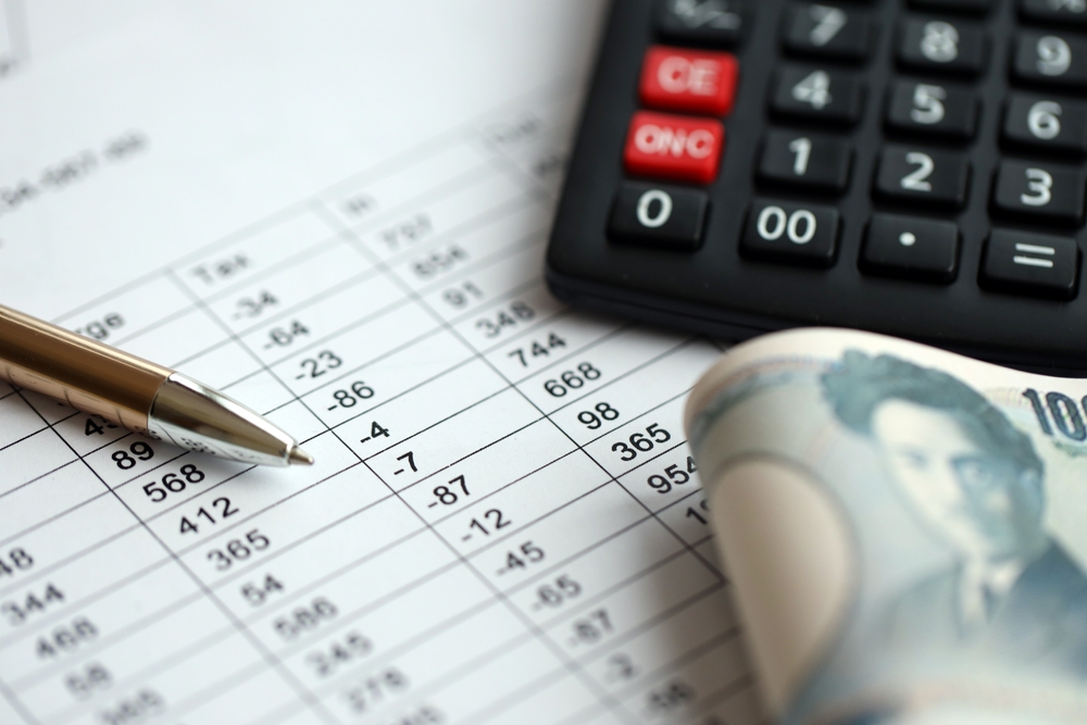 Japanese tax calculations lies on table with calculator, pen and japanese yen money bills close up