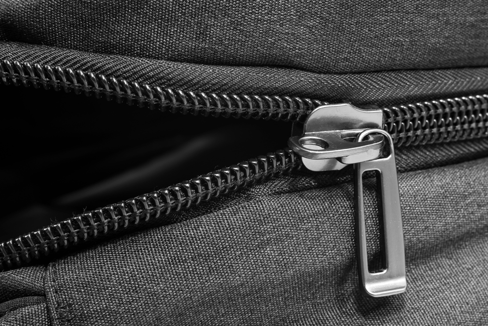 Silver lock with black zipper on clothes close-up. Zipper