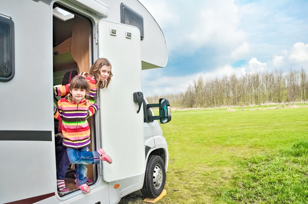 Kids in camper (rv) have fun, family travel in motorhome on holiday vacation trip in camping