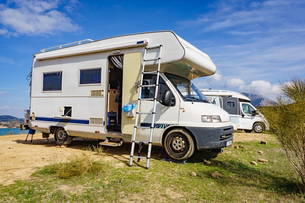 Camping on nature. Camper vehicle with portable ladder. Caravanning equipment, must have tool, maintain rv. Holiday trip with motor home.