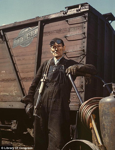 April 1943: Welder Mike Evans by the rip tracks at the Proviso yard of the Chicago and Northwest Railway Company in Chicago, Illinois