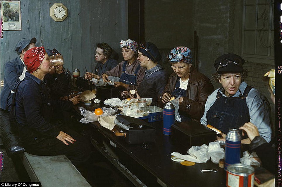 April 1943: Women workers in the roundhouse taking a lunch break in at the Chicago and Northwest Railway Company in Clinton, Iowa.