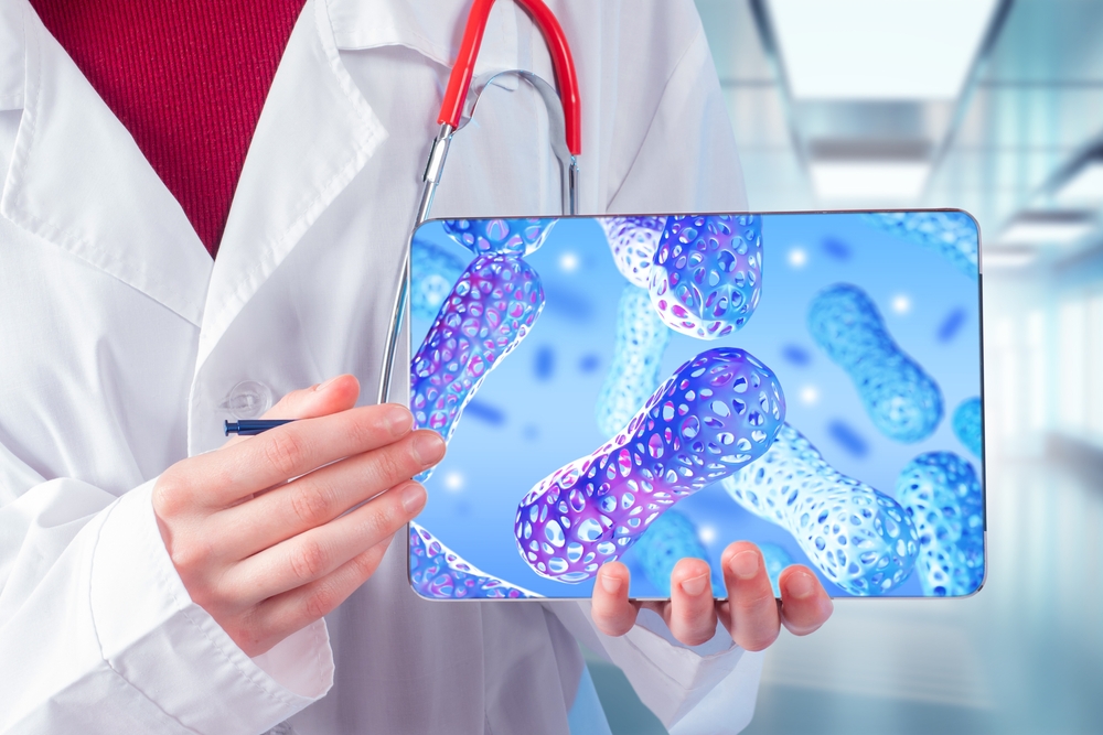 Doctor recommends probiotics. Microbiota cells on e-tablet. Molecules lactobacilli. Cropped doctor shows probiotic substance. Studying microbiota through electronic gadget. Probiotics for intestinal