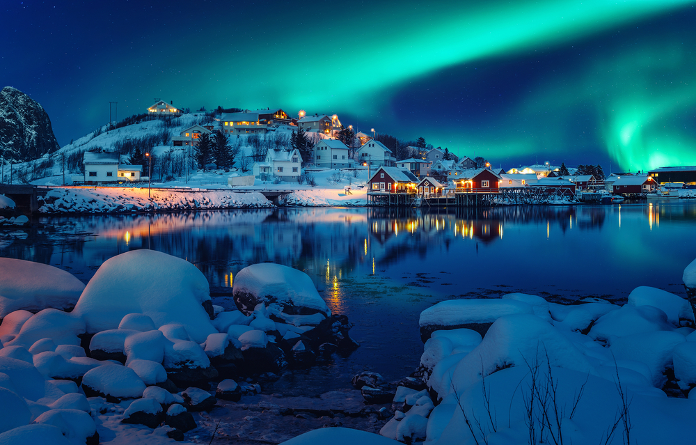 Scenic photo of winter fishing village with northern lights. stunning natural background. Picturesque Scenery of Reinefjord one most popular place of Lofoten islands. Norway. ideal resting place.