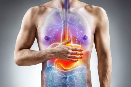 Digestion issue. Man holding his hand in area stomach. Medical concept.
