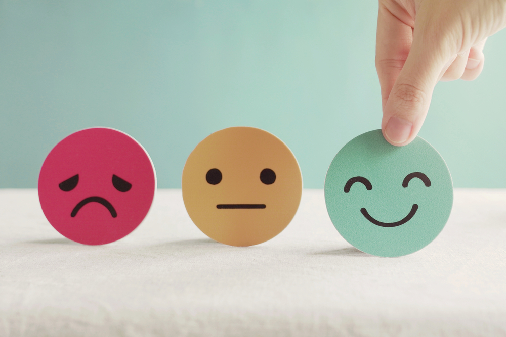 Hand choosing happy smile face paper cut, good feedback rating and positive customer review, experience, satisfaction survey ,mental health assessment, child wellness,world mental health day concept