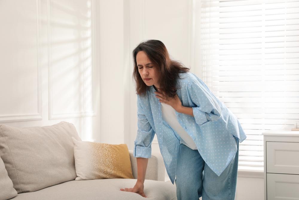 Mature woman suffering from breathing problem at home