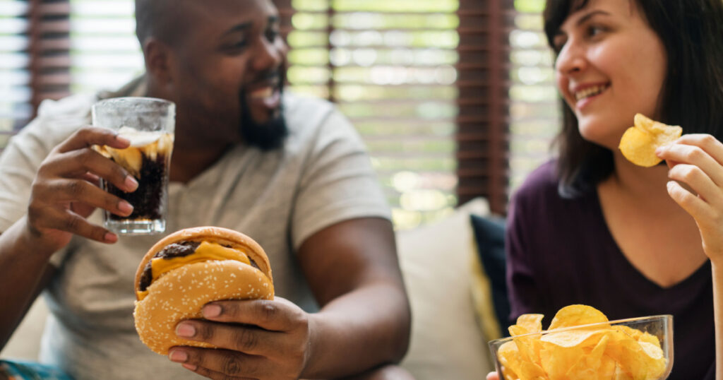 Couple having fast food on the couch