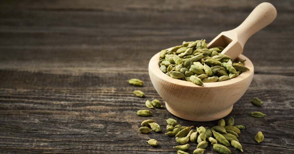 Cardamom in a wooden scoop