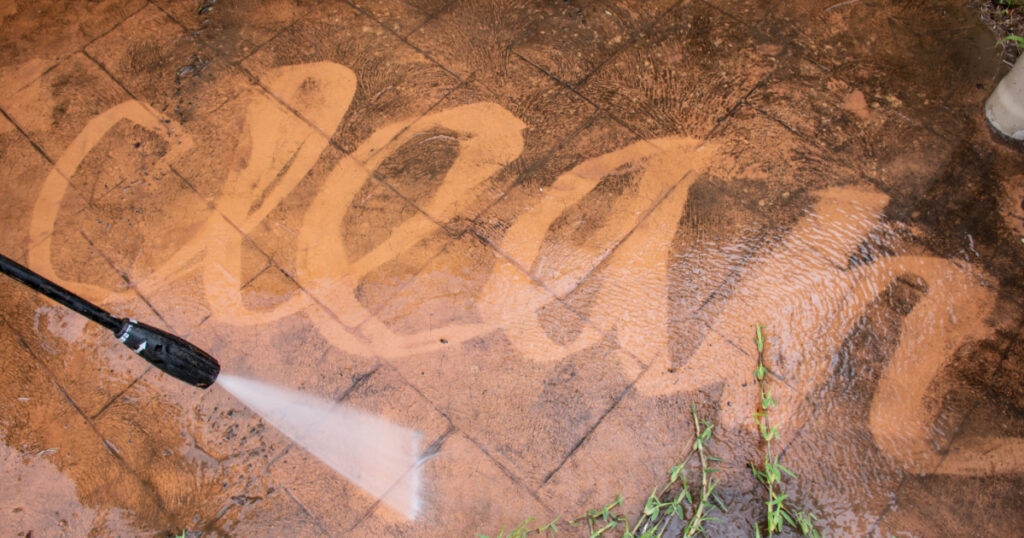 Cleaning backyard paving tiles with high pressure washer