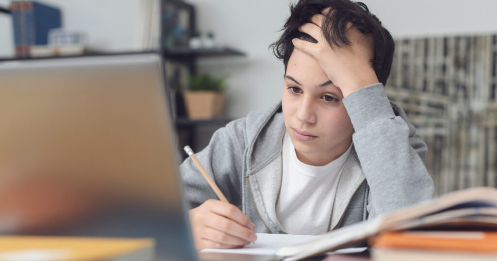 Tired student taking online classes, he is confused and staring at the computer screen