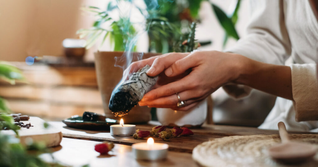 Woman hands burning white sage, palo santo