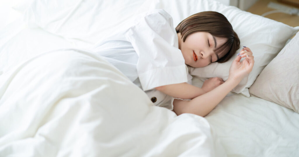 Female sleeping on a bed in a bright room