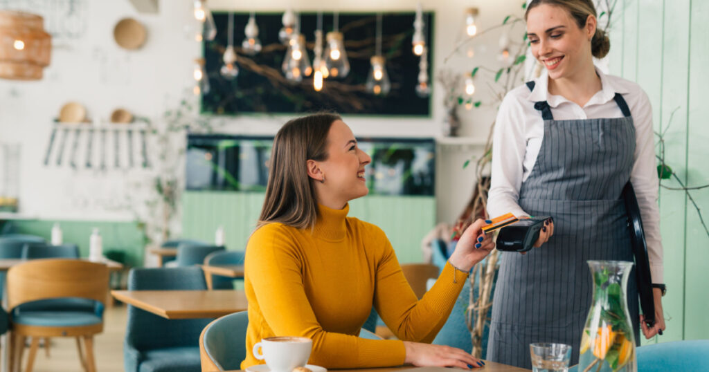 woman paying bill contactless with debit card