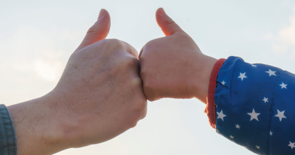 Thumbs Up Sign with Child and Father's Hand. Sky background.
Like sign.