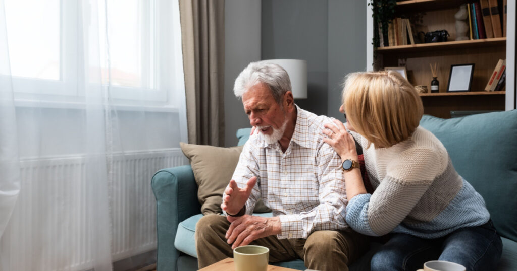 older couple sitting on sofa talking