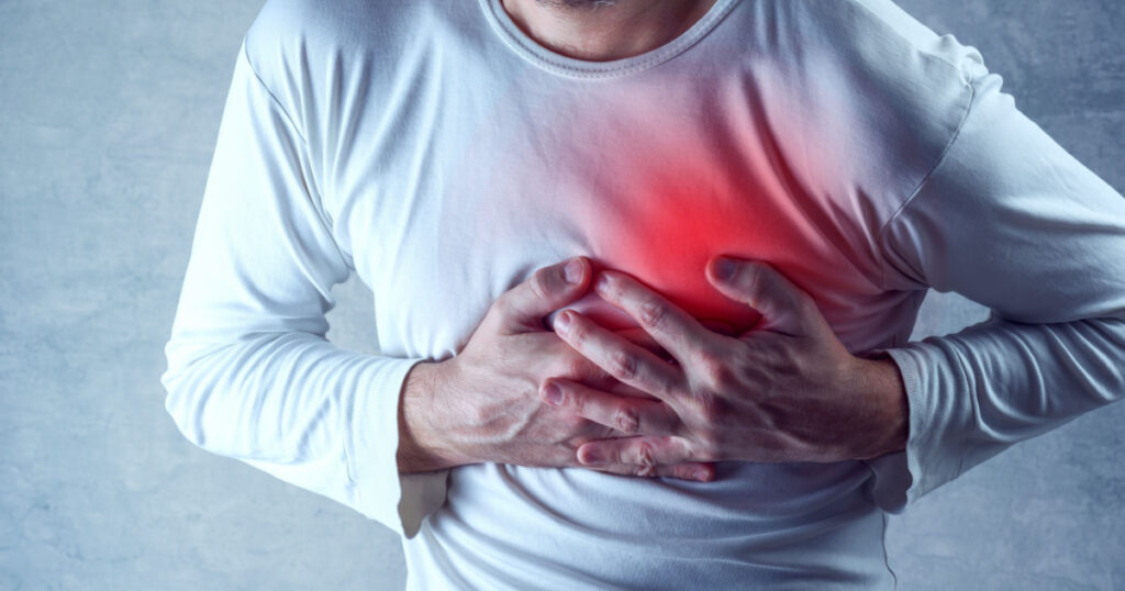 Severe heartache, man suffering from chest pain, having heart attack or painful cramps, pressing on chest with painful expression. sleep related diseases