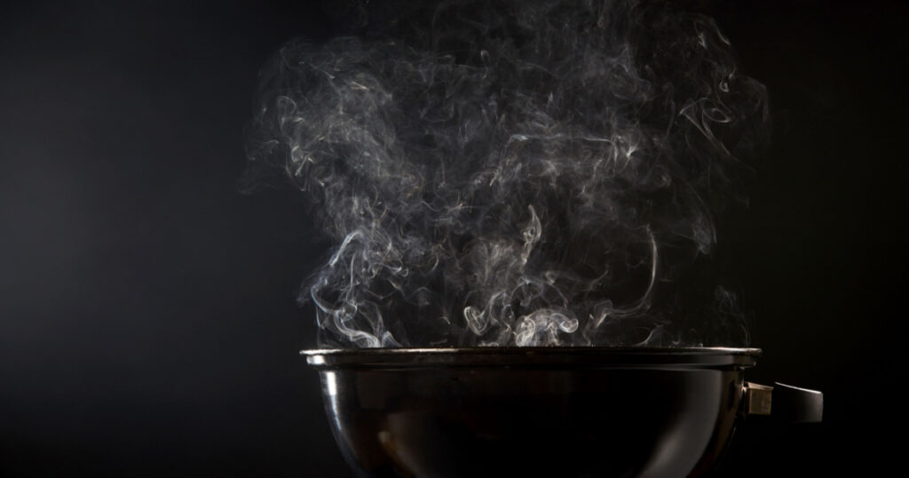 Smoke coming from a hot barbecue fire in a low angle view