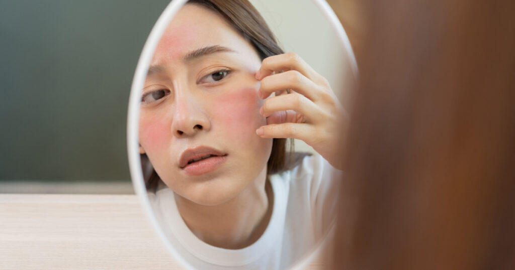 woman looking at face in the mirror