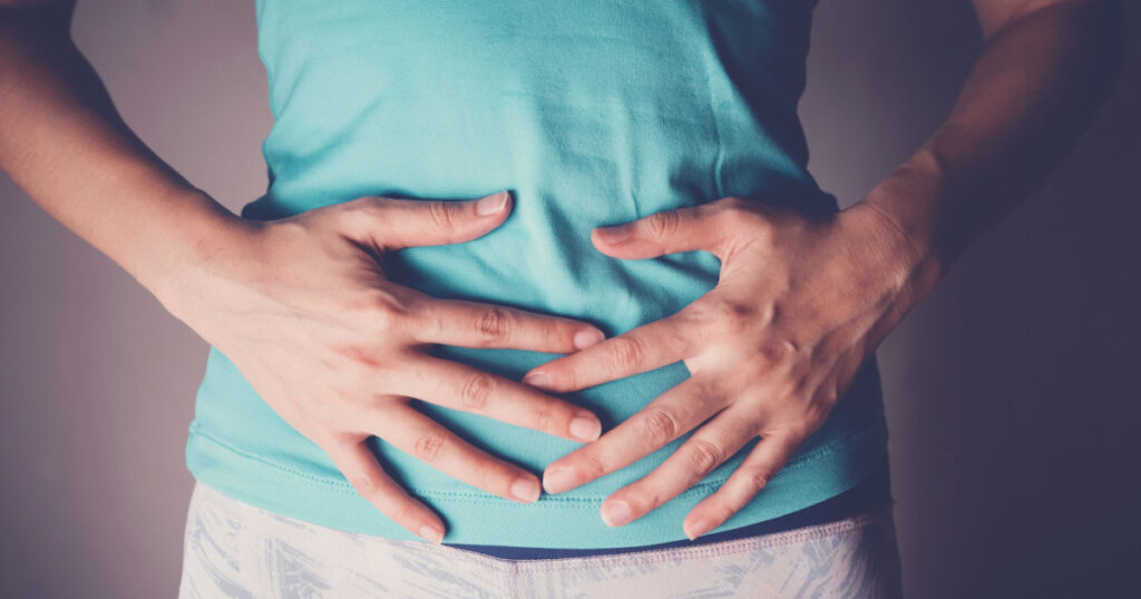 woman hands on her stomach, probiotics and prebiotics food for gut health, having stomachache, leaky gut, woman health