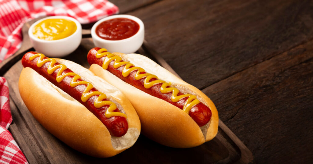 Hot dog with ketchup and yellow mustard.