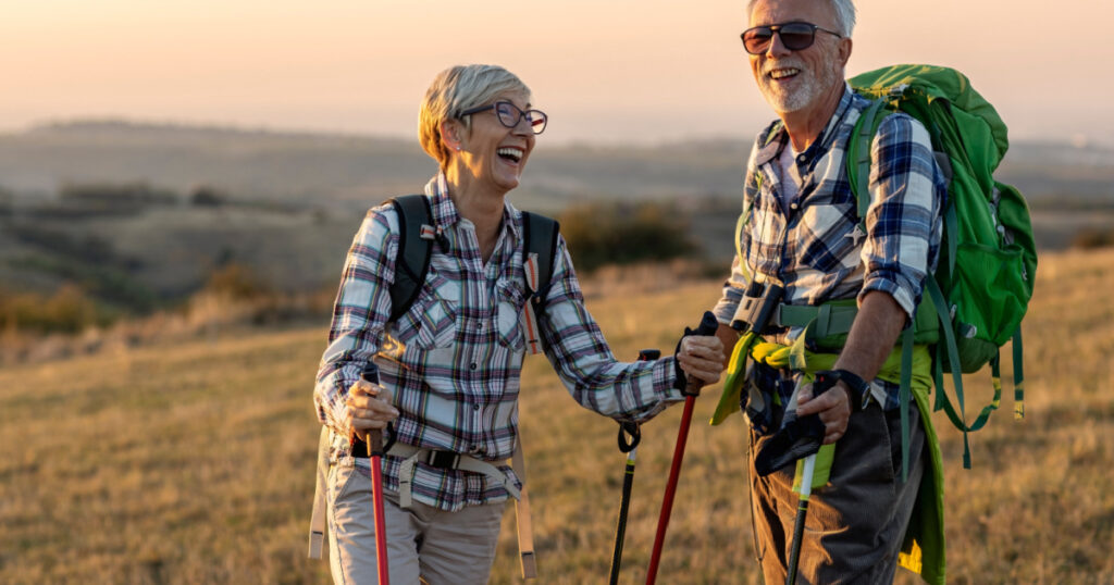 Old couple walking in nature and talk at sunset