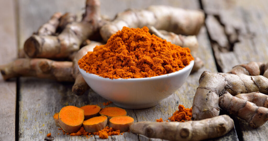 fresh turmeric roots on wooden table
