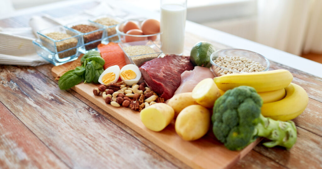 balanced diet, cooking, culinary and food concept - close up of vegetables, fruit and meat on wooden table

