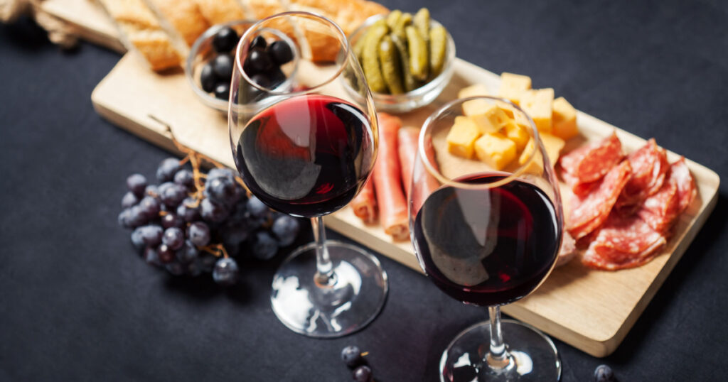 Red wine with charcuterie assortment on the background