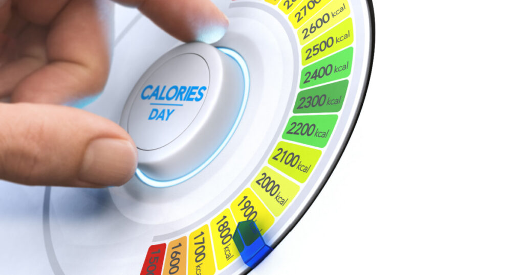 Man turning a calorie knob to reduce daily intake level. Composite image between a hand photography and a 3D background.